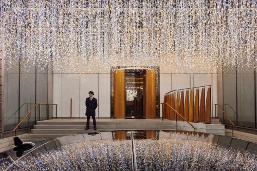 a man standing on steps in front of a building with lights at The Berkeley in London