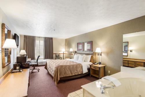 a hotel room with a bed and a bath tub at Quality Inn & Suites in Big Stone Gap