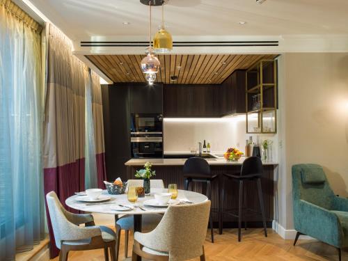 a kitchen and dining room with a table and chairs at The Guardsman - Preferred Hotels and Resorts in London