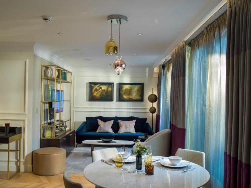 a living room with a blue couch and a table at The Guardsman - Preferred Hotels and Resorts in London