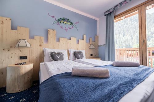 a bedroom with a large bed with a wooden headboard at Active Hotel Gran Zebru' in Cogolo