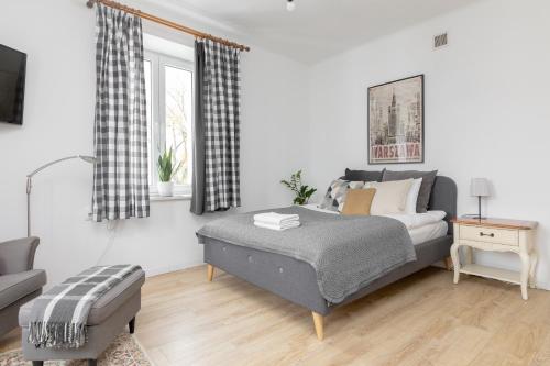 ein Schlafzimmer mit einem Bett und einem Sofa in der Unterkunft Park Promenada Cosy Apartment in Warschau