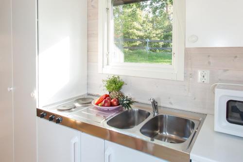 a kitchen with a sink and a bowl of fruit at Visby Strandby in Visby
