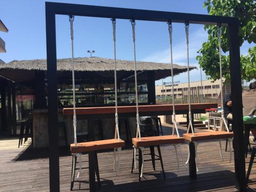 a group of swings in front of a pavilion at Hostal SolFina in Palafolls