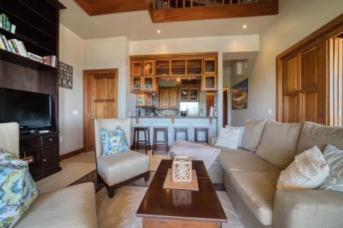 a living room with a couch and a kitchen at The Villas at Cocoplum in Placencia Village