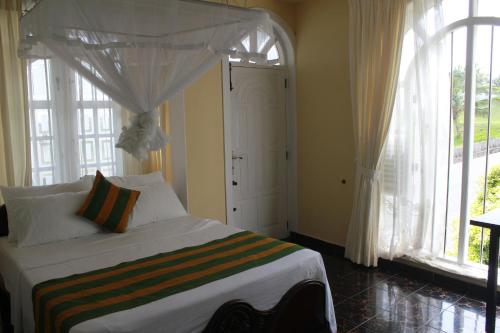 a bedroom with a bed with a canopy at Fort de 19 Villa - Galle Fort in Galle