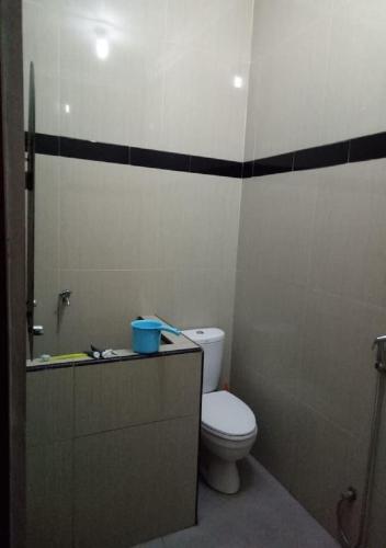 a small bathroom with a toilet and a shower at Homestay Kuning Ceria - Murah, Akses kota & wisata in Cijoho