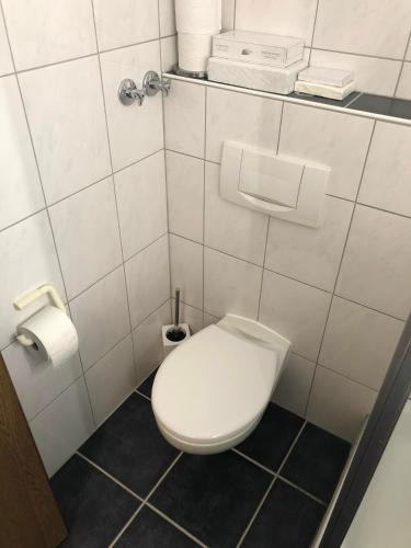 a bathroom with a toilet and a toilet paper dispenser at Hotel Bad Driburg in Bad Driburg