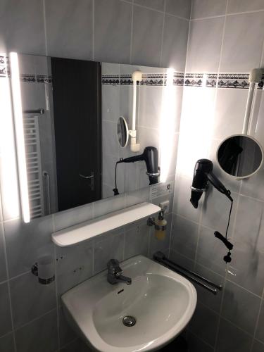 a bathroom with a sink and a mirror at Hotel Bad Driburg in Bad Driburg