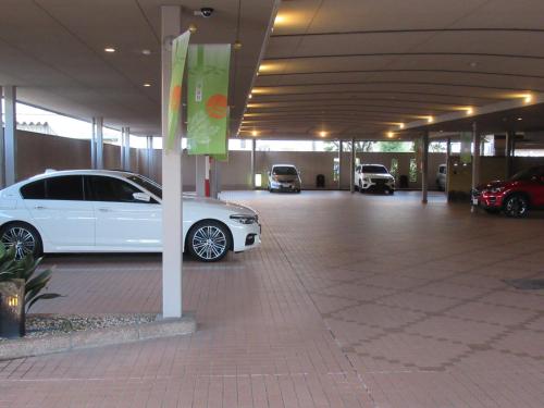 a white car parked in a parking lot at Hotel Shuyukan (Adult Only) in Izumi-Sano