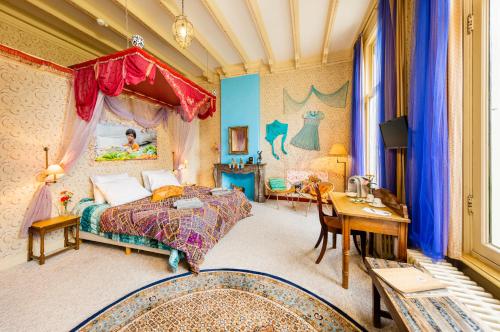 a bedroom with a bed and a desk and a table at Hotel Gaia in Diepenveen