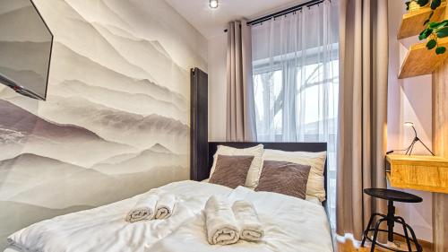 - une chambre avec un lit et des chaussons dans l'établissement Apartament Wood Lux - 5D Apartamenty, à Świeradów-Zdrój