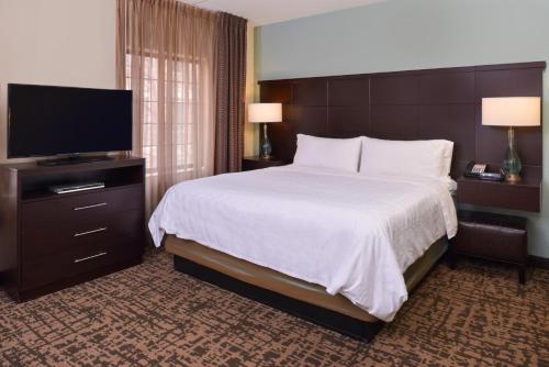 a hotel room with a bed and a flat screen tv at Staybridge Suites Indianapolis-Fishers, an IHG Hotel in Fishers