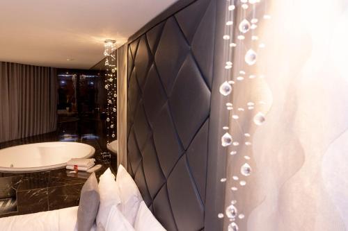 1 dormitorio con cabecero negro grande y bañera en Cancún Hotel by H Hotéis - Airport, en Brasilia