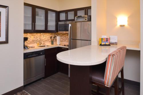 a kitchen with a table and a refrigerator at Staybridge Suites Indianapolis-Fishers by IHG in Fishers