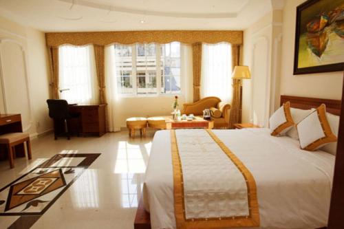 a bedroom with a large bed and a living room at Tan Hoang Long Hotel in Ho Chi Minh City