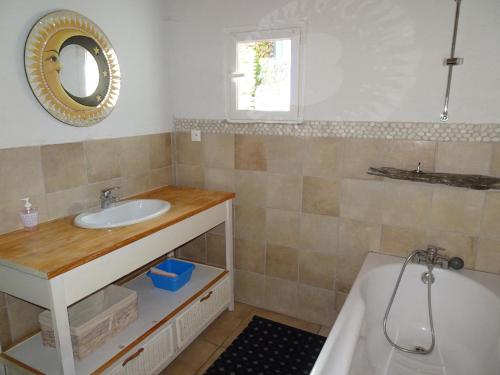 La salle de bains est pourvue d'un lavabo, d'une baignoire et d'un miroir. dans l'établissement Auberg'IN Gîte, à Mirandol-Bourgnounac