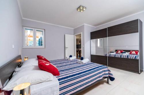 a bedroom with two beds with red pillows at Luxury Apartment Marina View No 1 in Vela Luka
