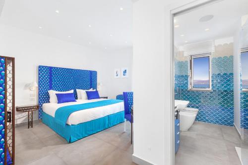 ein blau-weißes Schlafzimmer mit einem Bett und einem Badezimmer in der Unterkunft Amore Rentals - Villa del Maggiore in Sorrent
