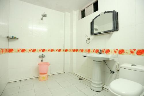 a bathroom with a sink and a toilet and a mirror at Calux Hill Queen at Mall Road with Parking - Formerly Amara in Mussoorie