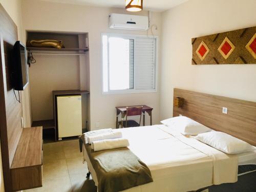 En eller flere senge i et værelse på Brasil Hotel