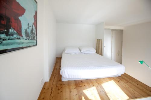 - une chambre avec un lit blanc et du parquet dans l'établissement Place Saint Michel Apartment, à Bordeaux