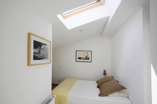 a bedroom with a bed in a white room at Les Terrasses de Louise in Bordeaux