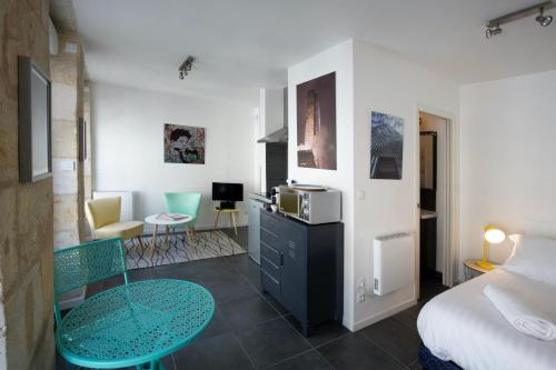 um pequeno quarto com uma cama e uma mesa num quarto em Appartement Bordeaux Centre Historique em Bordéus