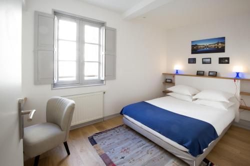 une chambre avec un lit, une chaise et une fenêtre dans l'établissement Centre historique - Le Maubec, à Bordeaux
