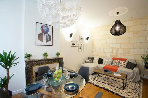 ein Wohnzimmer mit einem Sofa und einem Tisch in der Unterkunft Appartement Luxe - La Devise in Bordeaux