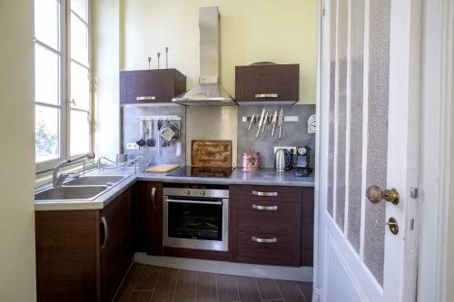 une cuisine avec un évier et une cuisinière dans l'établissement Centre historique, appartement climatisé avec terrasse, à Bordeaux