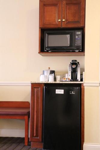 a kitchen with a black refrigerator and a microwave at Best Western Springfield Hotel in Springfield
