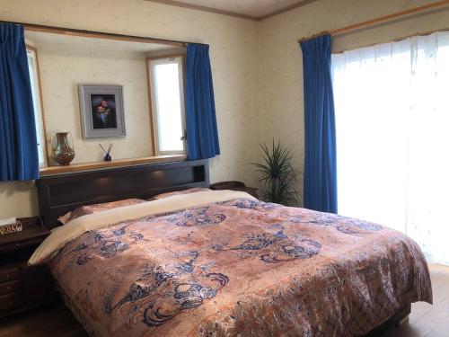 Schlafzimmer mit einem Bett mit einem Spiegel und einem Fenster in der Unterkunft Kamogawa - House - Vacation STAY 9977 in Kamogawa