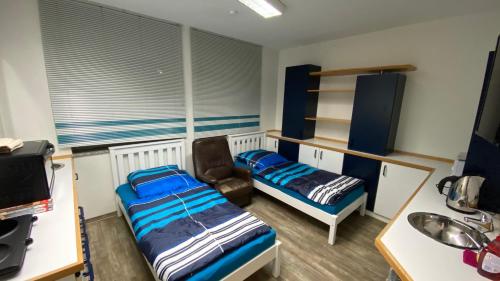 a room with two beds and a chair in it at Lindenstraße in Belm