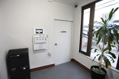 a room with a plant and a door and a window at Saitama Kyodo Building - Vacation STAY 02388v in Saitama