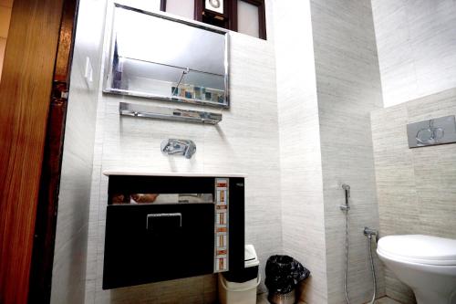 baño con aseo y TV en la pared en Amara Hill Queen Mussoorie en Mussoorie