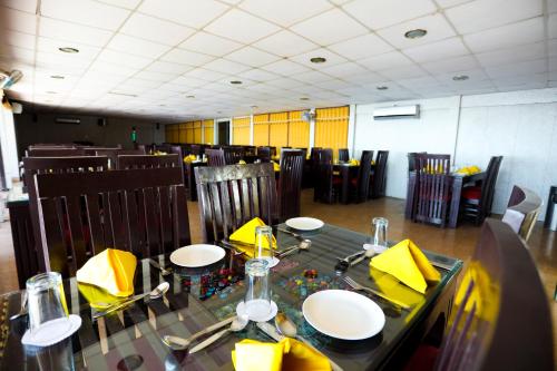 a dining room with a table and chairs with yellow napkins at Calux Hill Queen at Mall Road with Parking - Formerly Amara in Mussoorie