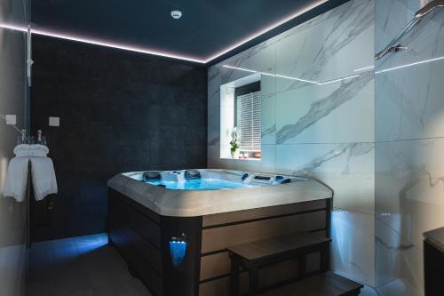een badkamer met een groot bad en een spiegel bij B&B La Siesta in Markovci