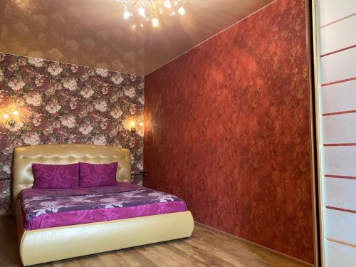 a bedroom with a purple bed and red wall at New apartments with panoramic views on Avenue Nauky in Kharkiv