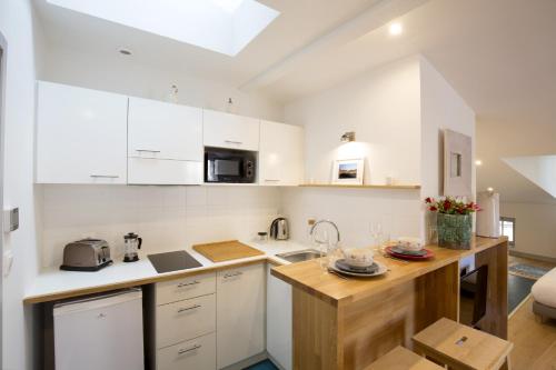 une cuisine avec des armoires blanches et un comptoir en bois dans l'établissement Centre Historique - Tour du Pin 3, à Bordeaux