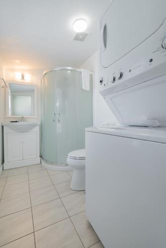 a white bathroom with a toilet and a shower at 306 E Arctic Ave. in Folly Beach