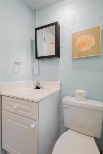 a bathroom with a white toilet and a mirror at 306 E Arctic Ave. in Folly Beach