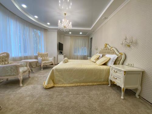 sypialnia z dużym łóżkiem i żyrandolem w obiekcie Sofievsky Posad Hotel w Kijowie