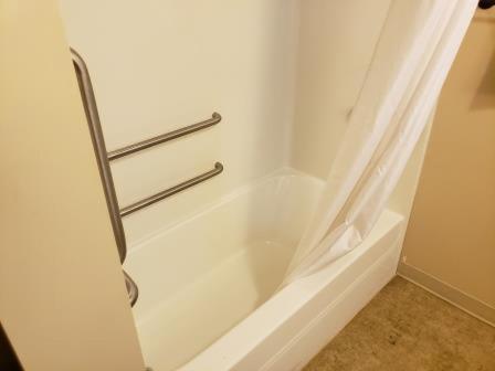 eine weiße Badewanne mit Duschvorhang im Bad in der Unterkunft Clarion Hotel & Suites Near Pioneer Power Generating Station in Williston