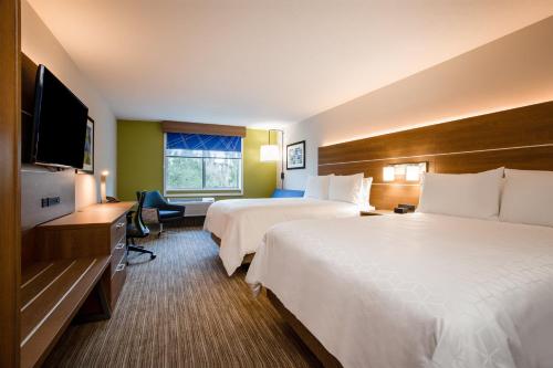 a hotel room with two beds and a flat screen tv at Holiday Inn Express & Suites - Deland South by IHG in DeLand