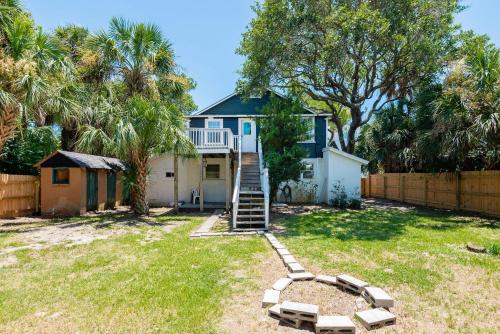 a house with a staircase in a yard at 306 E Arctic Ave. in Folly Beach
