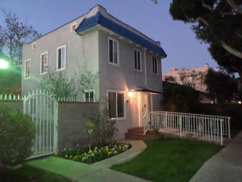 una casa blanca con una valla y un patio en Rest Haven Motel, en Los Ángeles