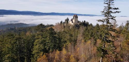 a castle on the top of a mountain with clouds at hotel ZLATÝ POTOK in Nicov
