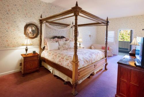 a bedroom with a canopy bed and a table with lamps at Hotel La Rose in Santa Rosa