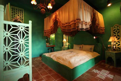 1 dormitorio con 1 cama en una habitación verde en A Fei Surf Inn III, en Nanwan